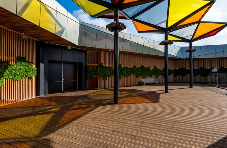 Holzterrasse mit farbigem Sonnendach